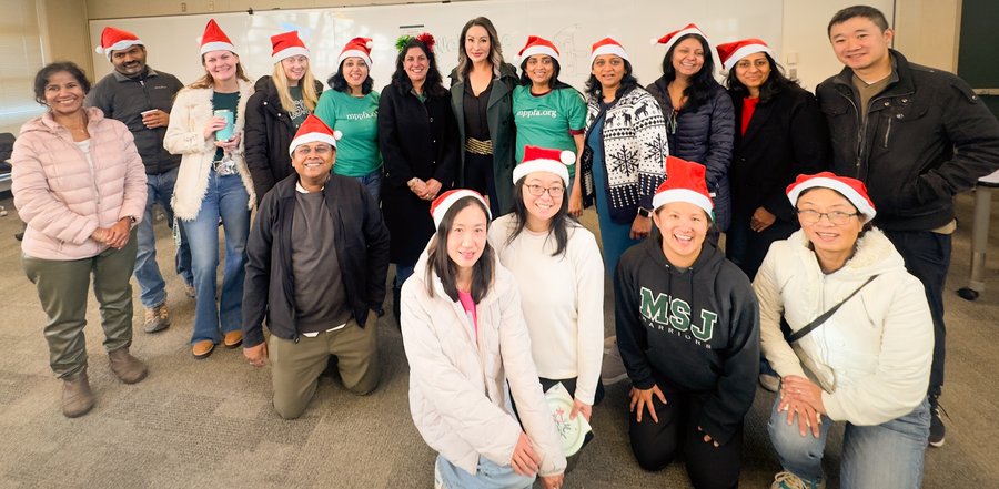 Full group photo with Santa hats at Holiday Breakfast